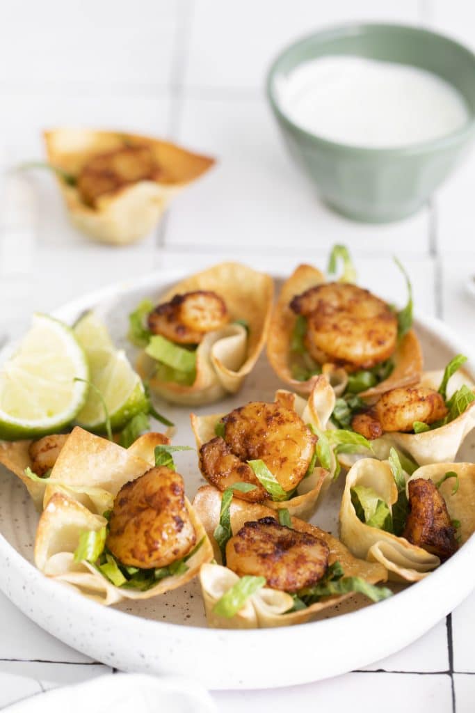 a white plate full of shrimp taco bites in wonton cups