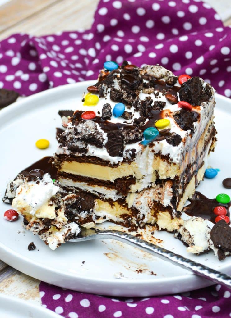 a fork and a slice of homemade ice cream sandwich cake resting on a white plate