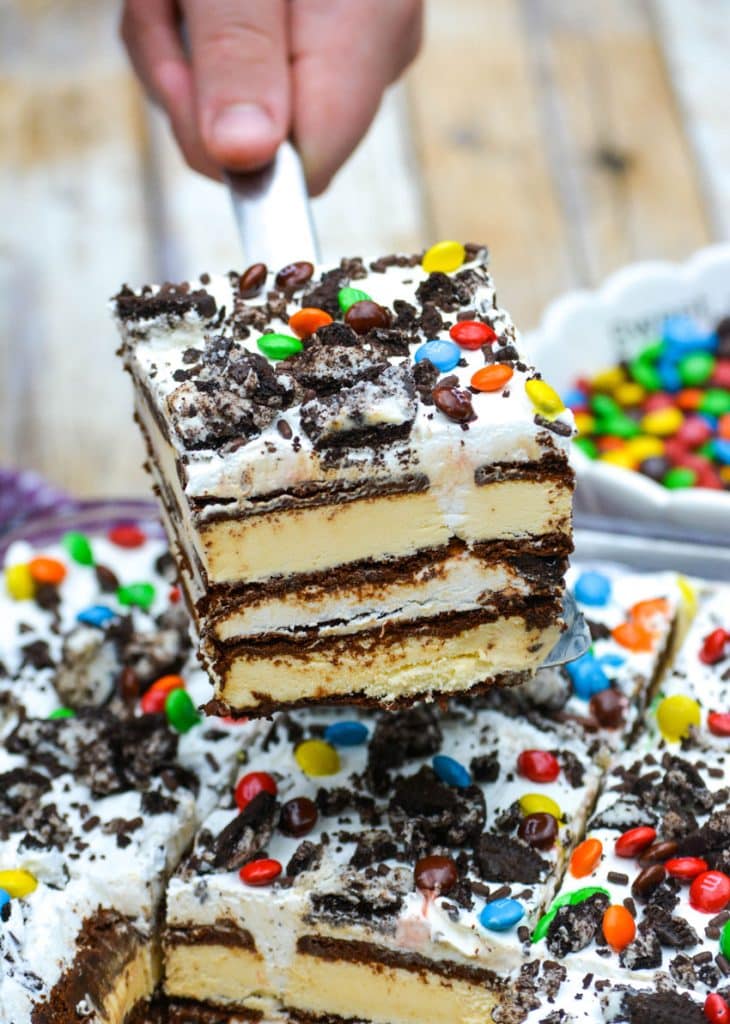 a silver spatula lifting a slice of ice cream sandwich cake from a baking dish