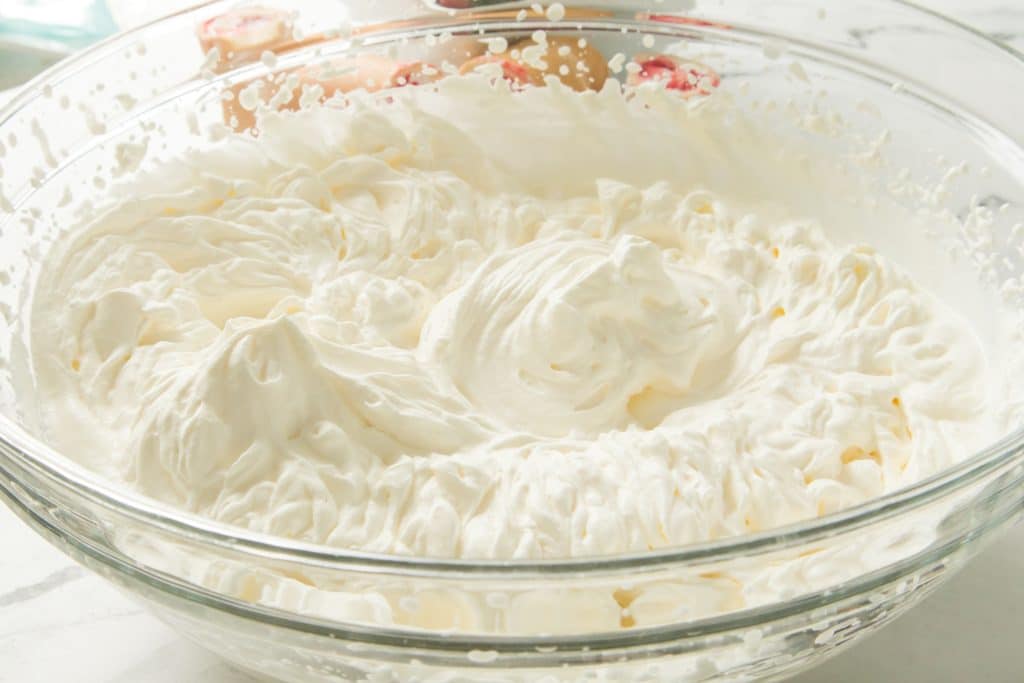 heavy cream whipped in a glass mixing bowl