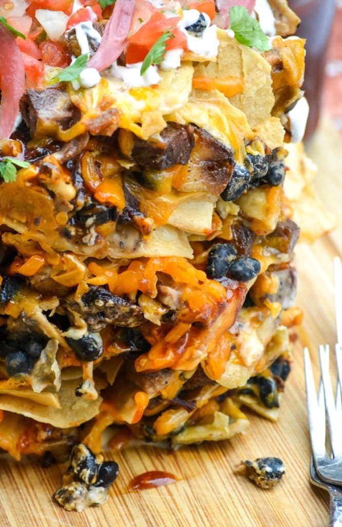 stacked trash can nachos on a wooden cutting board