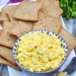 ham and egg salad in a purple bowl surrounded by pieces of party toast