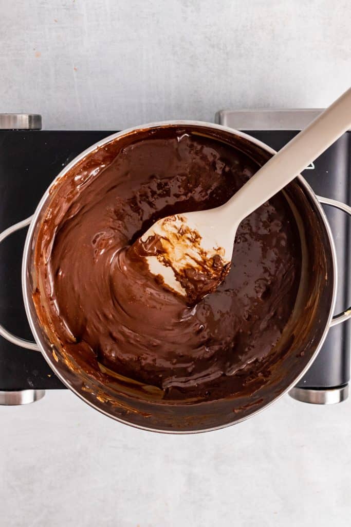a spatula in a pot of smooth chocolate sauce
