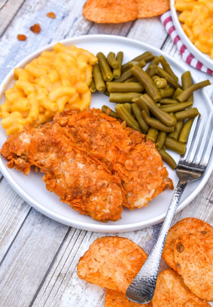 barbecue potato chip chicken tenders on a white plate with mac and cheese and green beans on the side