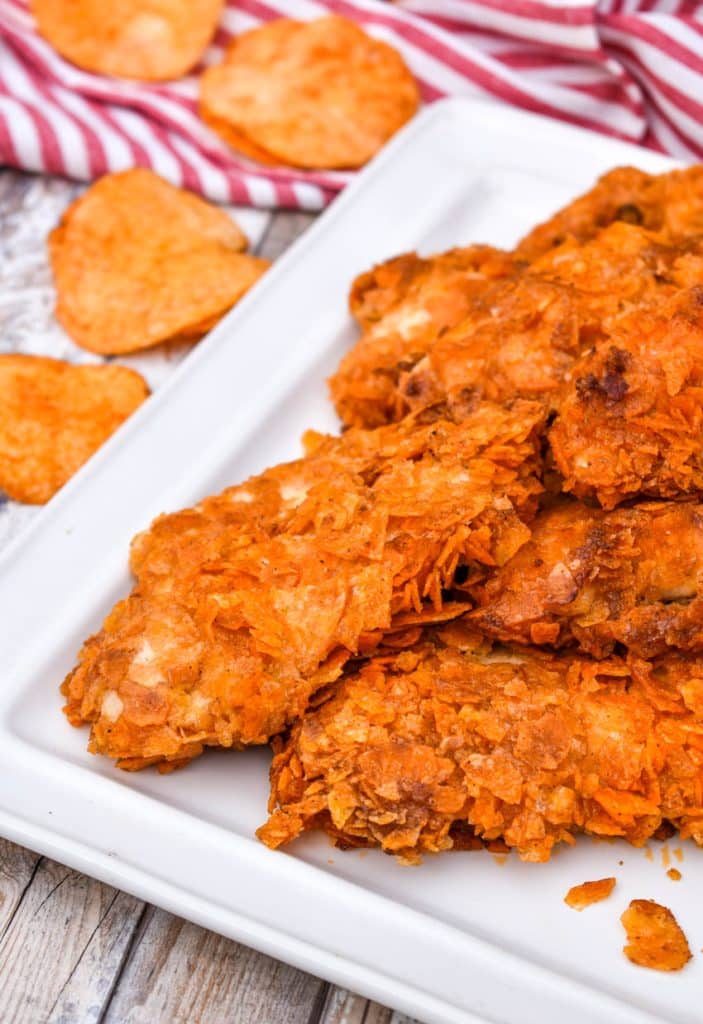 baked barbecue chip chicken tenders stacked on a white platter