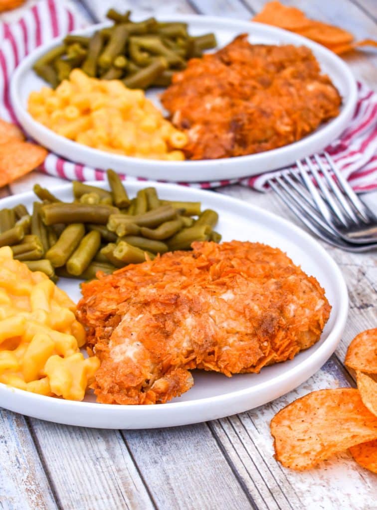 barbecue potato chip chicken tenders on a white plate with mac and cheese and green beans on the side