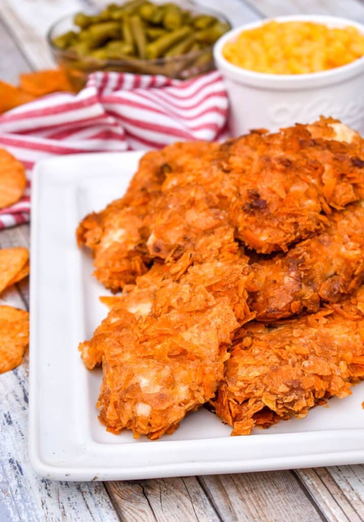 baked barbecue chip chicken tenders stacked on a white platter