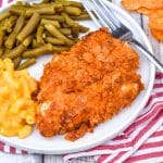 barbecue potato chip chicken tenders on a white plate with mac and cheese and green beans on the side