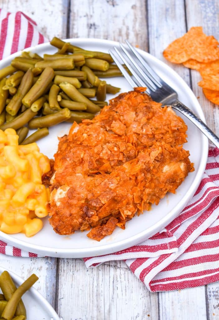 barbecue potato chip chicken tenders on a white plate with mac and cheese and green beans on the side