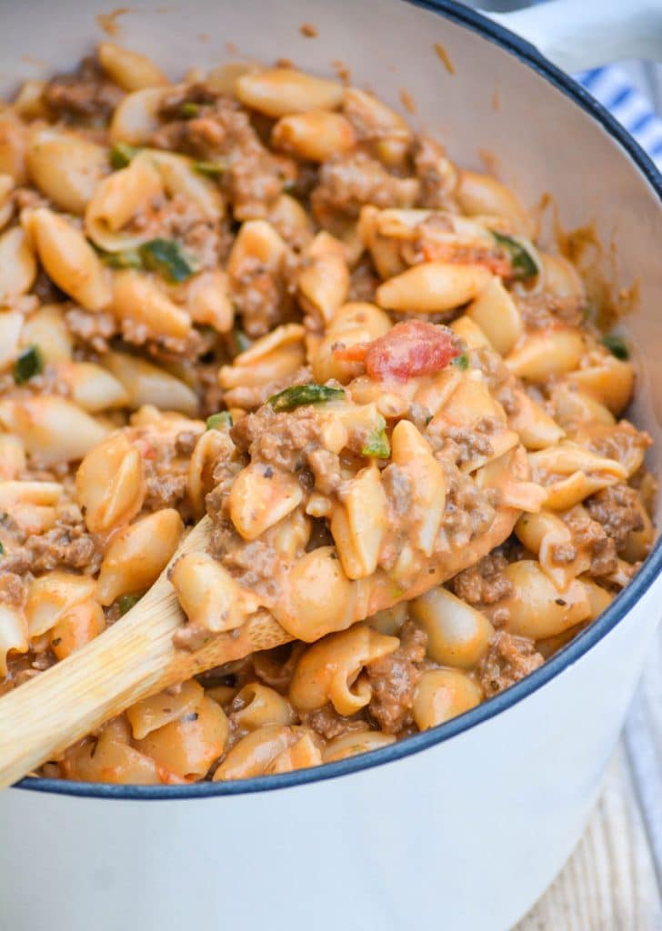a wooden spoon in a pot of mac and cheese goulash