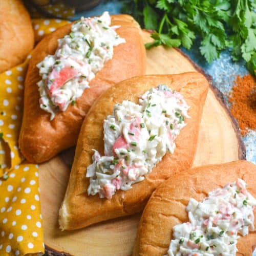 seafood salad in bolillo rolls on a wooden cutting board