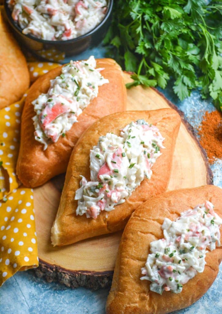 seafood salad in bolillo rolls on a wooden cutting board