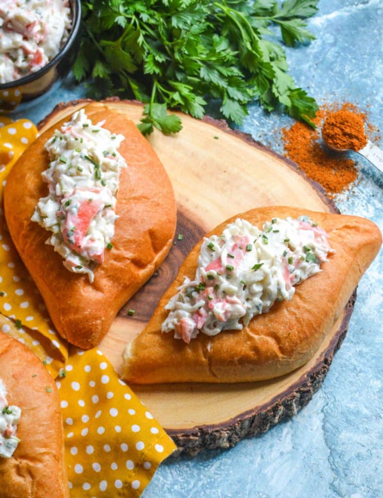 seafood salad in bolillo rolls on a wooden cutting board
