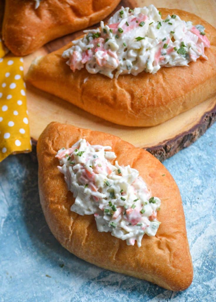 seafood salad in bolillo rolls on a wooden cutting board