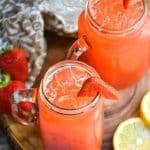 easy strawberry lemonade in glasses over ice on a wooden cutting board