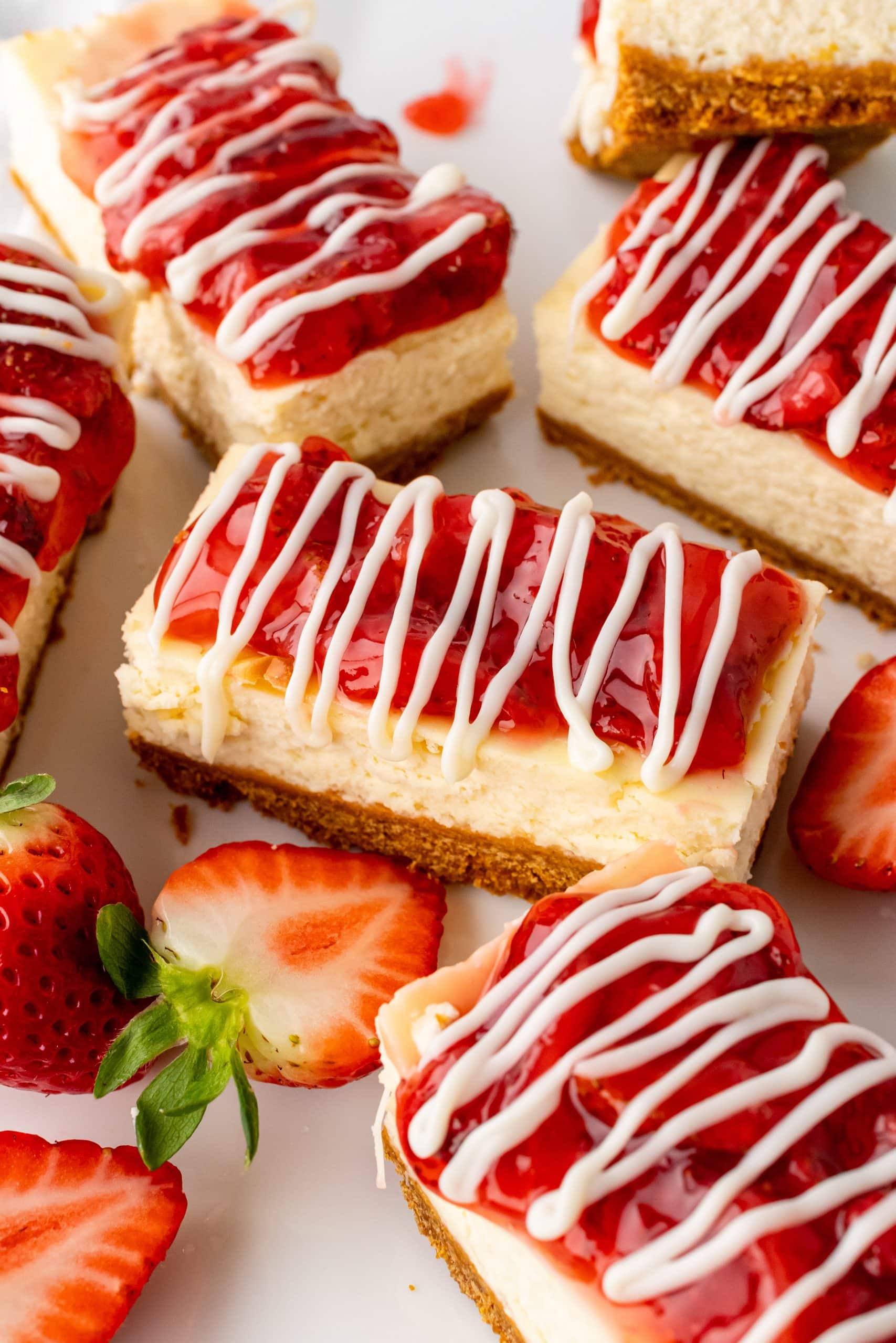 Copycat Philadelphia Strawberry Cheesecake Snack Bars cut Philadelphia strawberry cheesecake snack bars arranged next to fresh berries