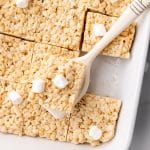 a white spatula holding up a marshmallow topped rice krispies treat square