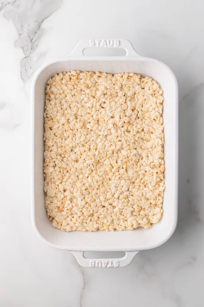 slow cooker rice krispie treats spread in a white casserole dish