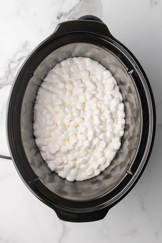 marshmallows melting in the black bowl of a slow cooker