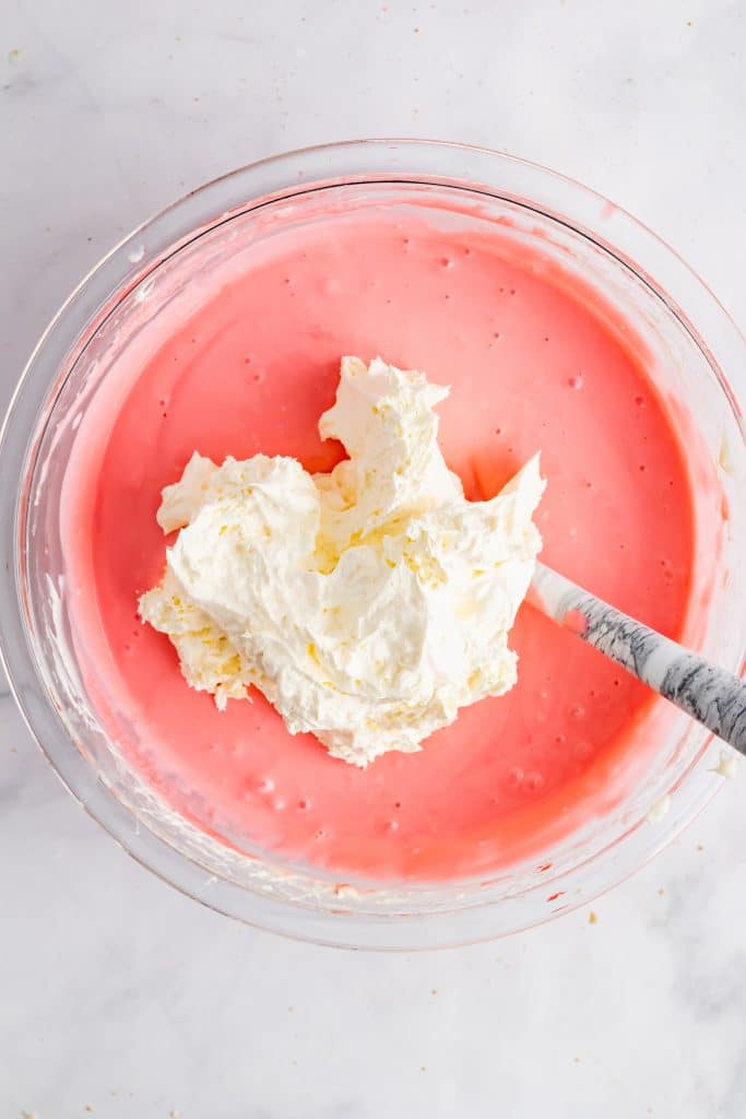 whipped topping added to a mixing bowl of strawberry pie filling