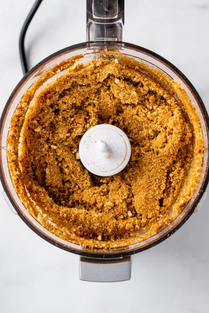buttered pretzel pieces in the bowl of a food processor