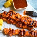barbecue chicken kabobs with pineapple and bacon on metal skewers