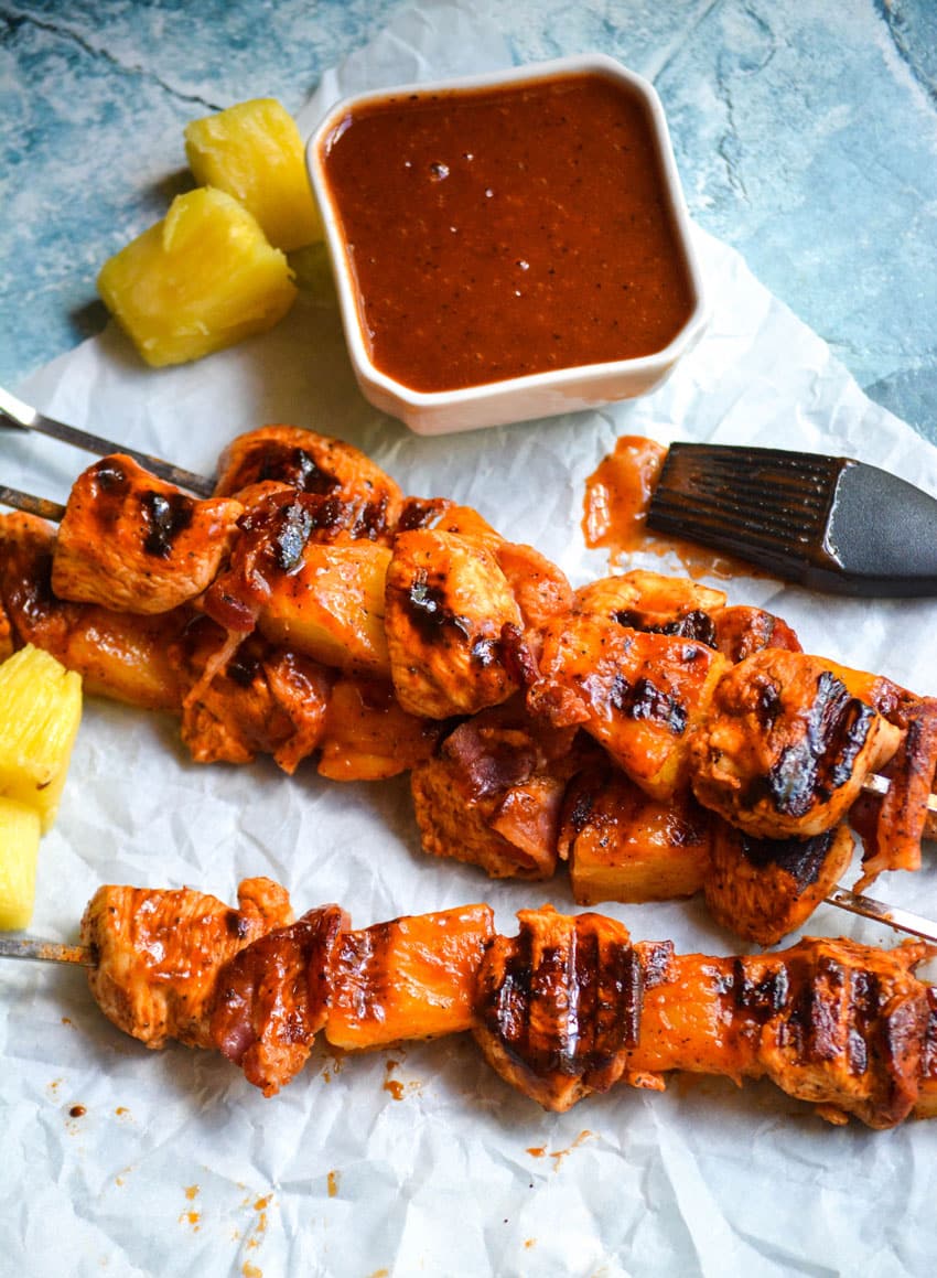 barbecue chicken kabobs with pineapple and bacon on metal skewers