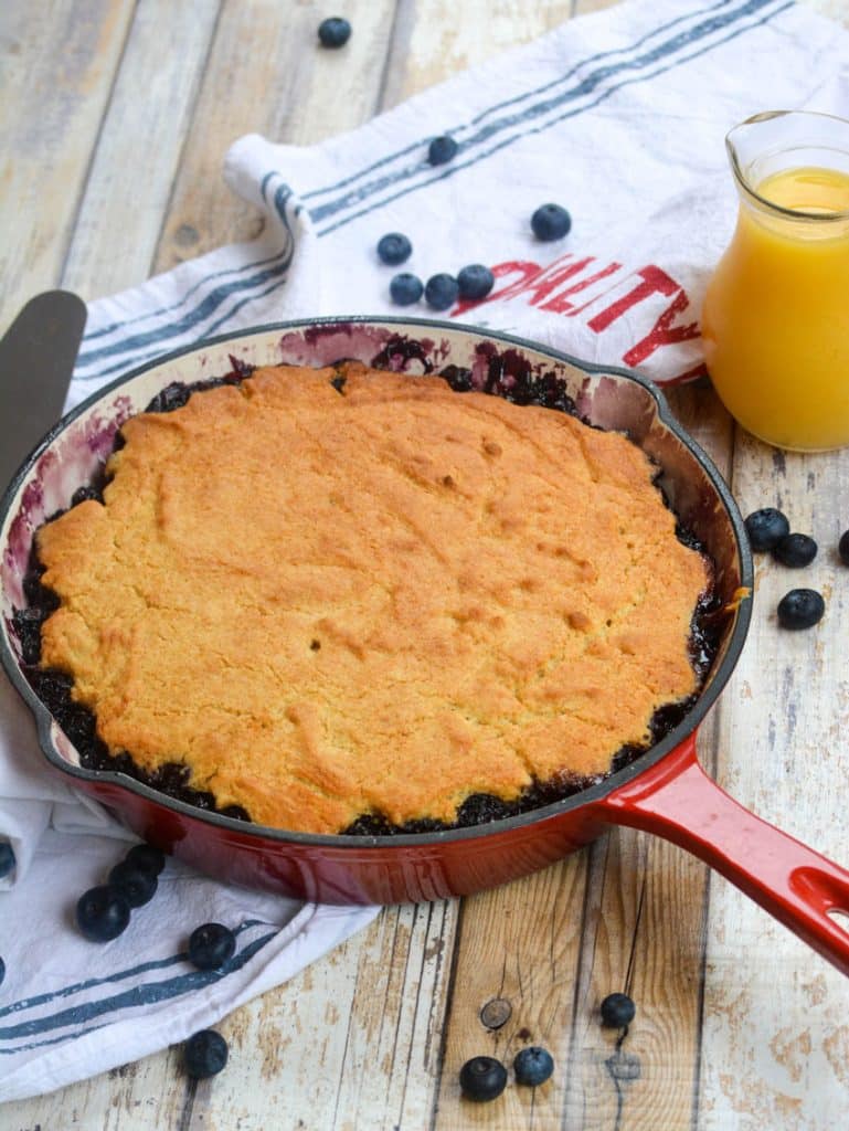 blueberry upside down cake in a red enameled cast iron skillet
