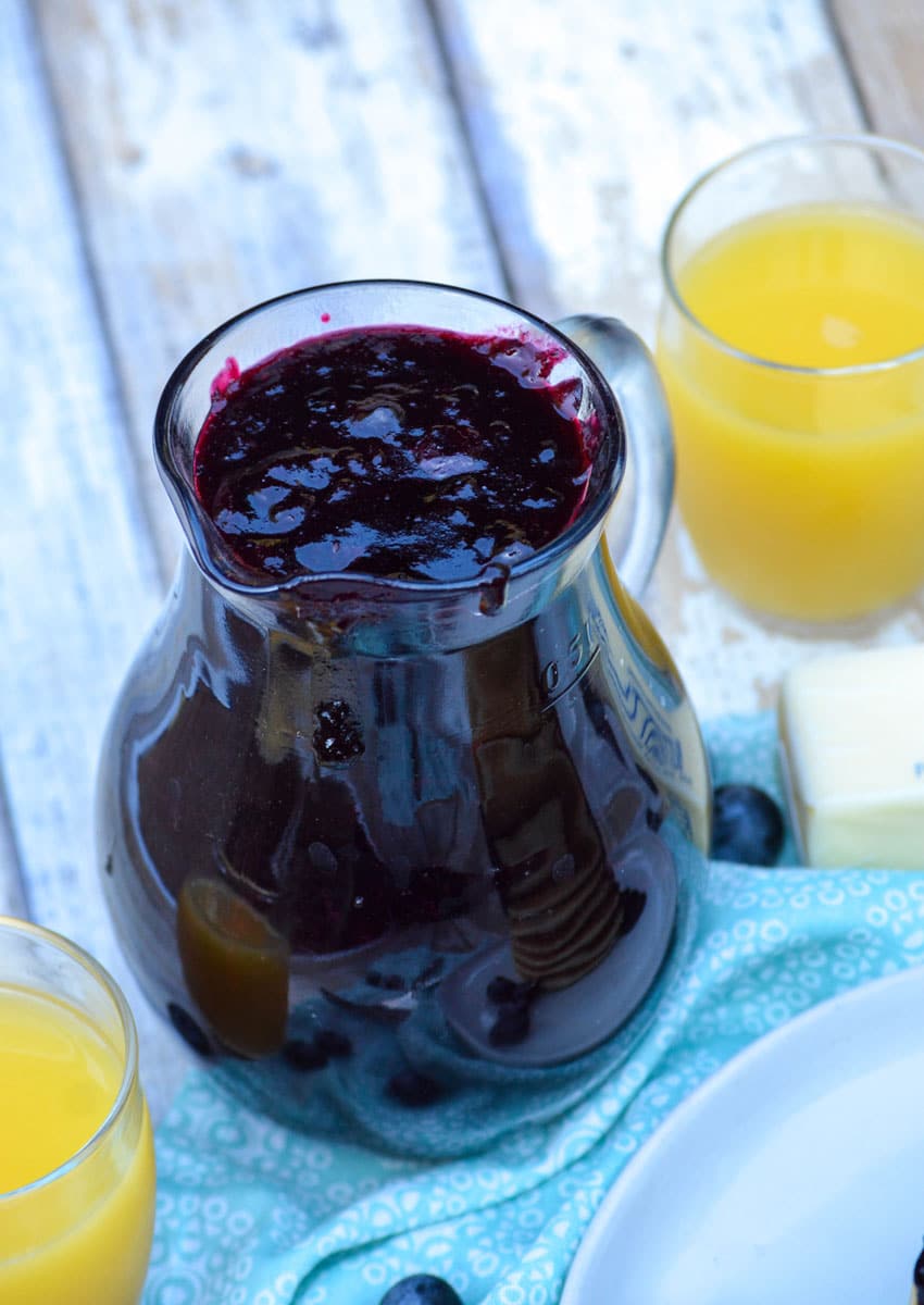 simple stove top blueberry syrup in a small glass pitcher