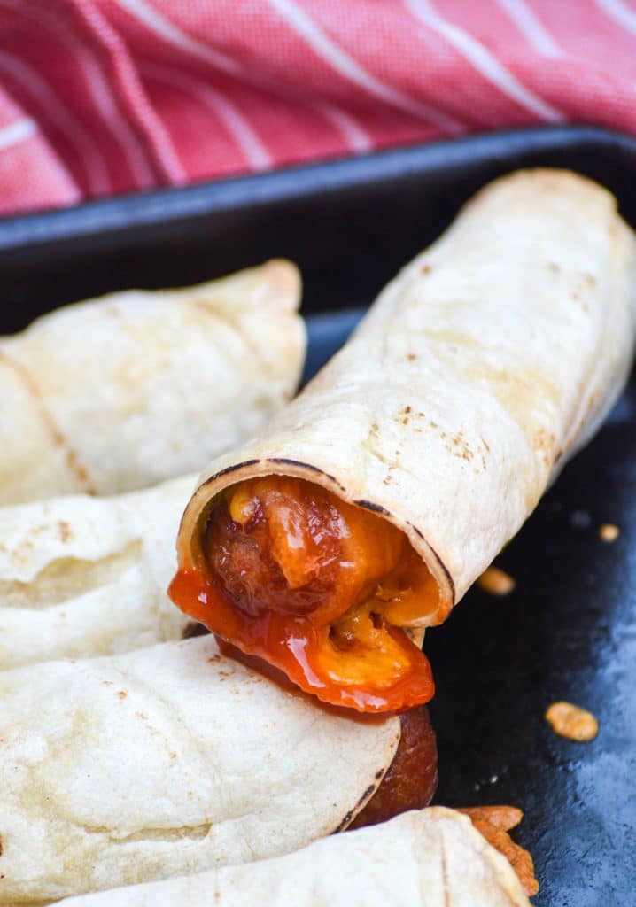 ketchup dipped leftover hotdog taquito resting on another taquito