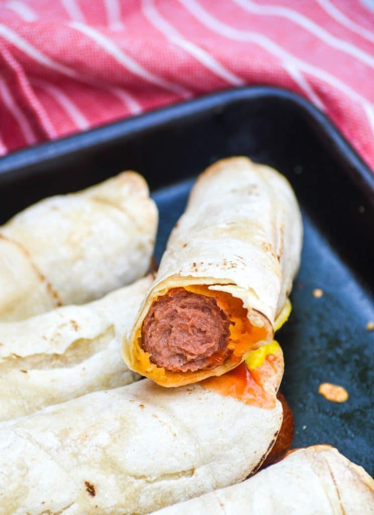 ketchup dipped leftover hotdog taquito resting on another taquito