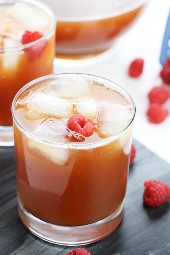 raspberry iced tea in glasses surrounded by fresh berries