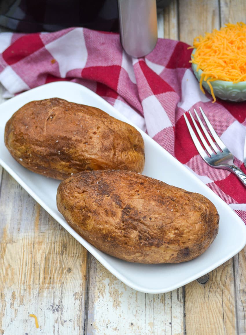 air fryer baked potatoes on a small white platter