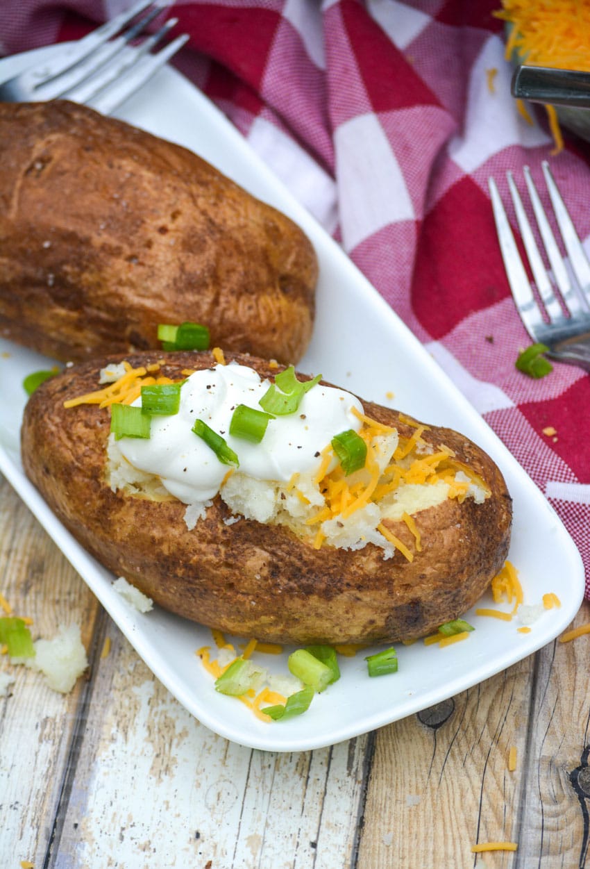 two air fried baked potatoes on a small white platter