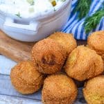 easy homemade hushpuppies in a pile in front of a gray bowl filled with dill pickle dip