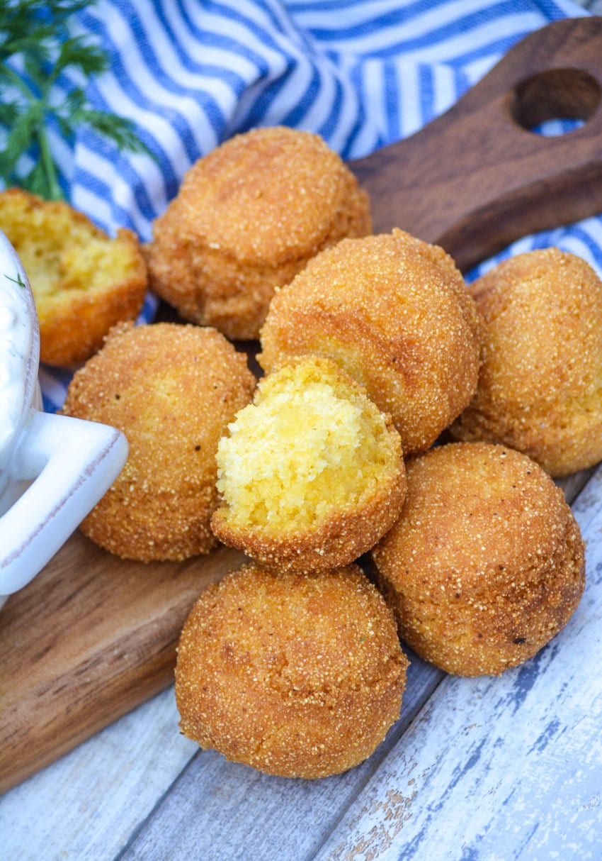 a homemade hushpuppy broken open to reveal the fluffy yellow center