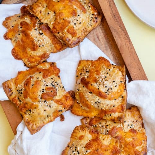 savory breakfast hand pies on a white cloth covered wooden serving tray
