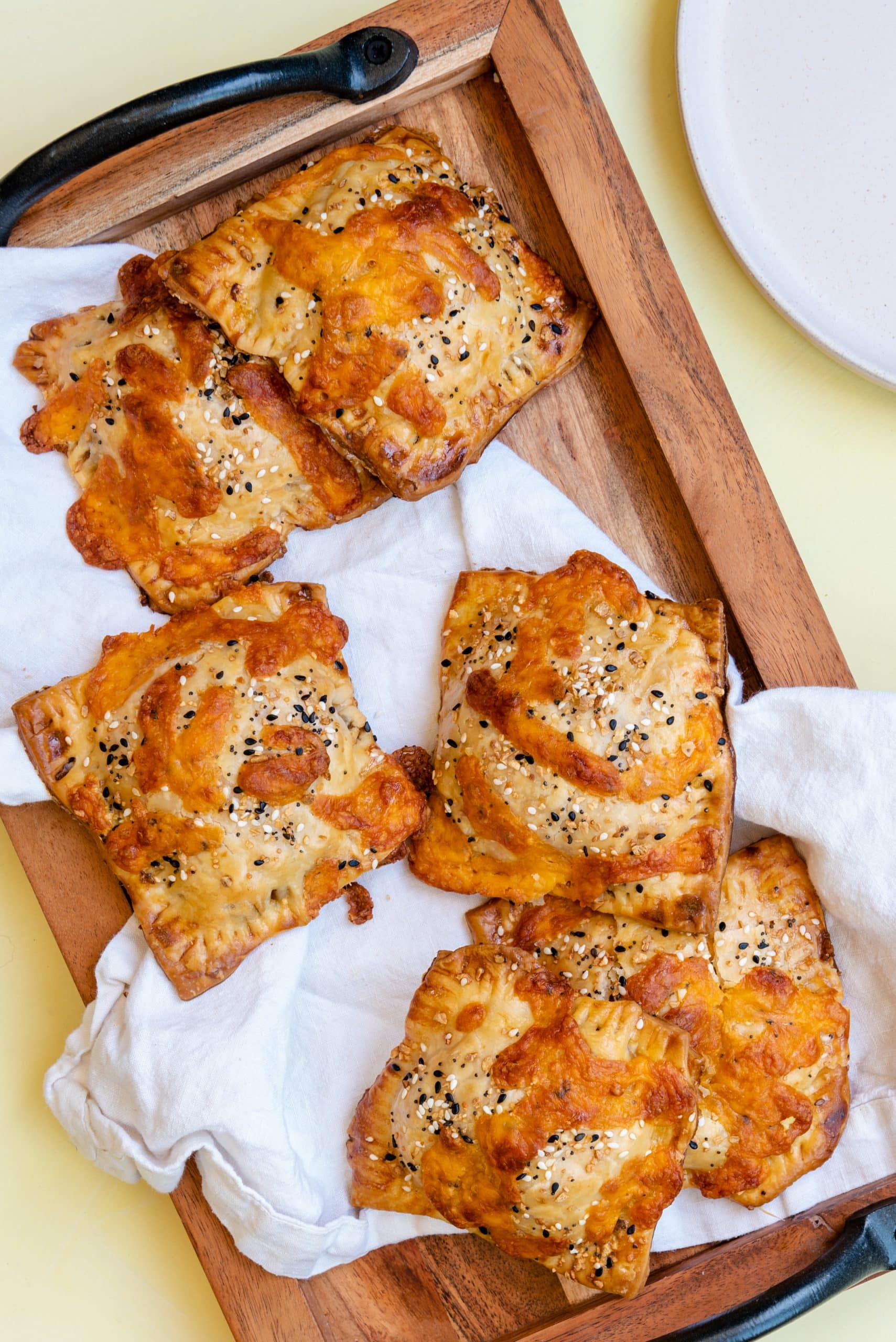 savory breakfast hand pies on a white cloth covered wooden serving tray