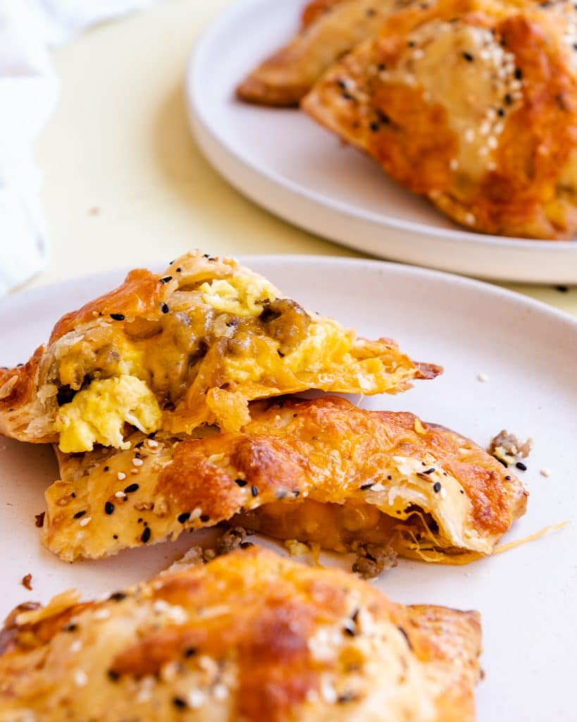 savory breakfast hand pies broken in half on a white plate