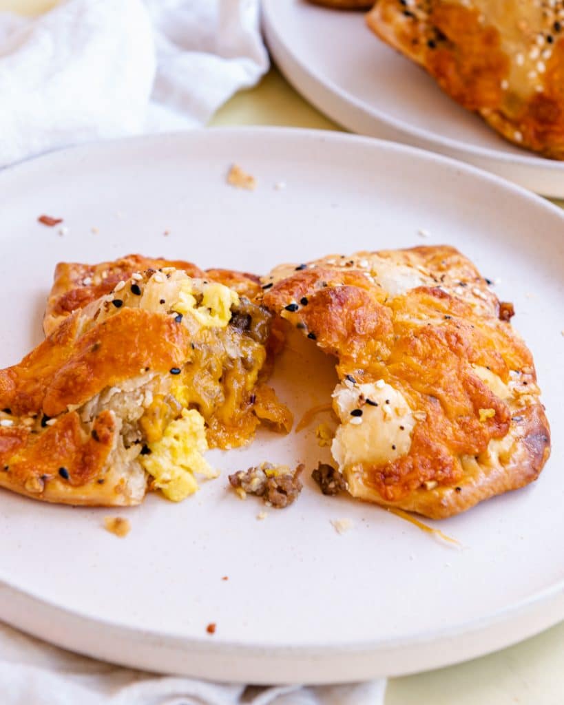 savory breakfast hand pies broken in half on a white plate