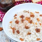 breakfast rice in a white bowl topped with pecans and crumbled bacon