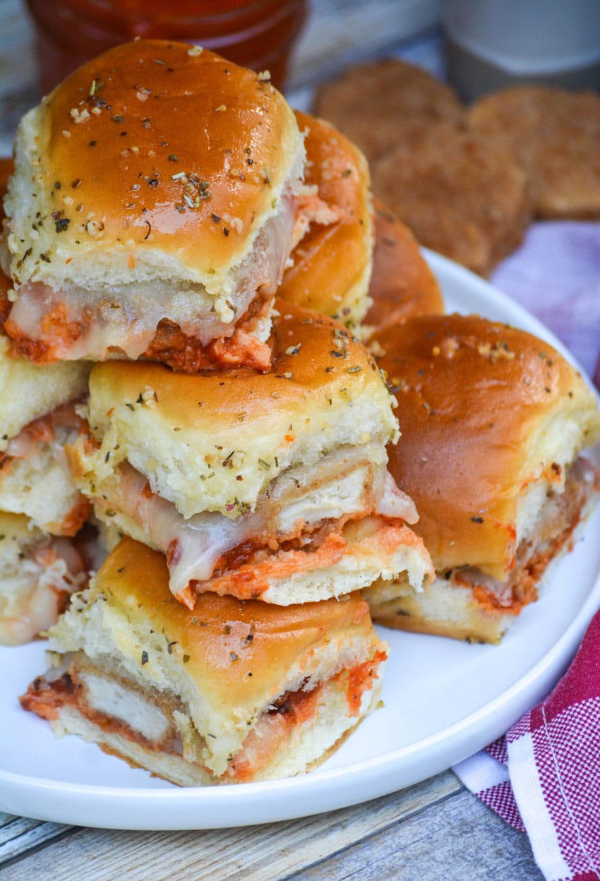 a stack of cheesy chicken parmesan nugget sliders on a white plate