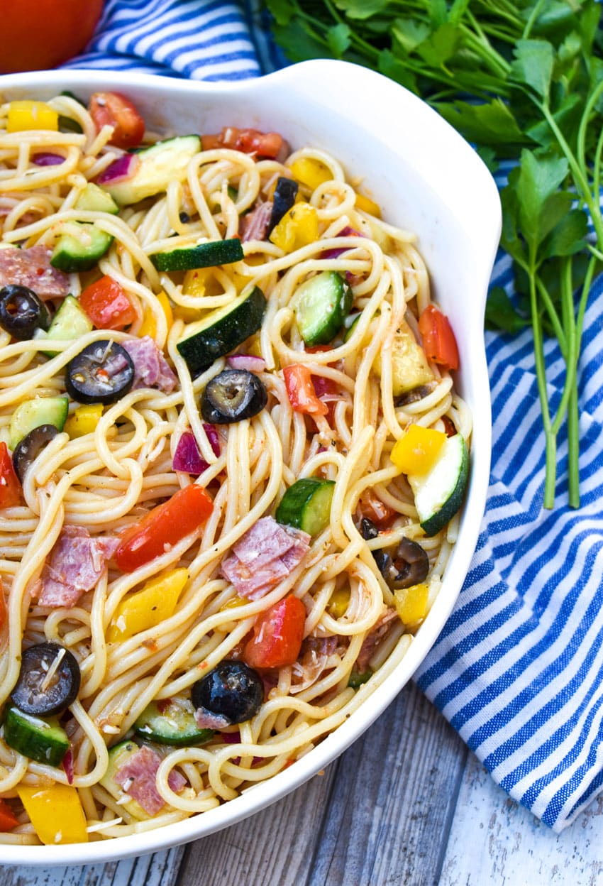 Italian summer spaghetti salad in a large white serving bowl