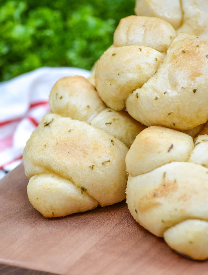 20 minute garlic knots piled on a wooden cutting board