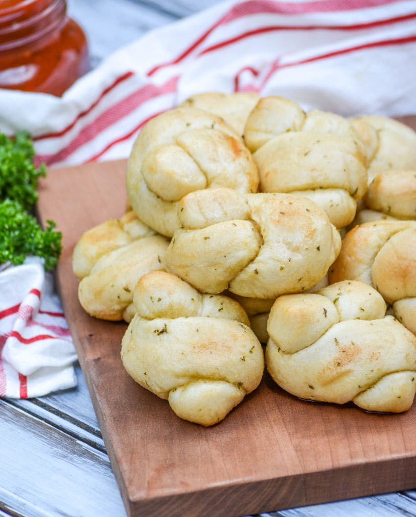 a pile of 20 minute garlic knots on a wooden cutting board