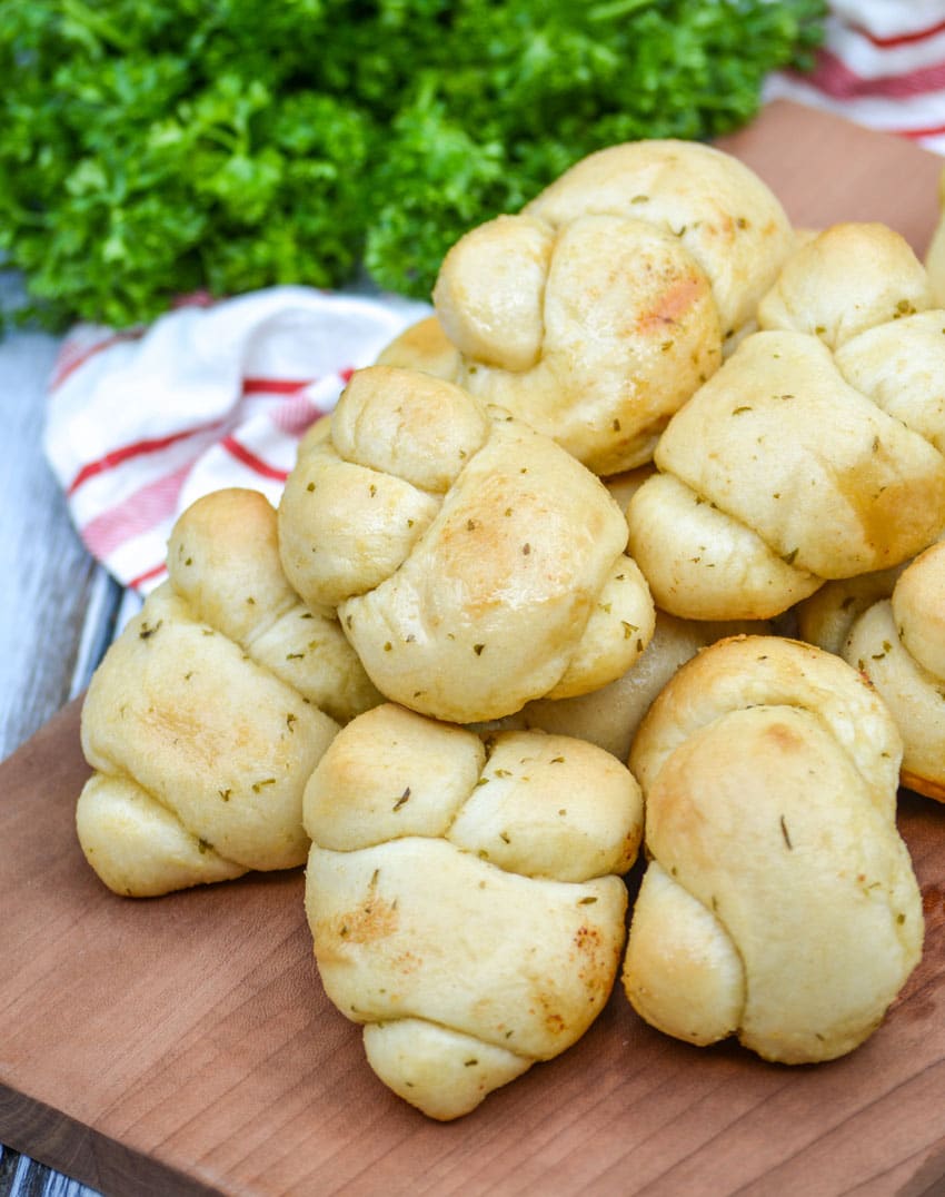 20 minute garlic knots piled on a wooden cutting board