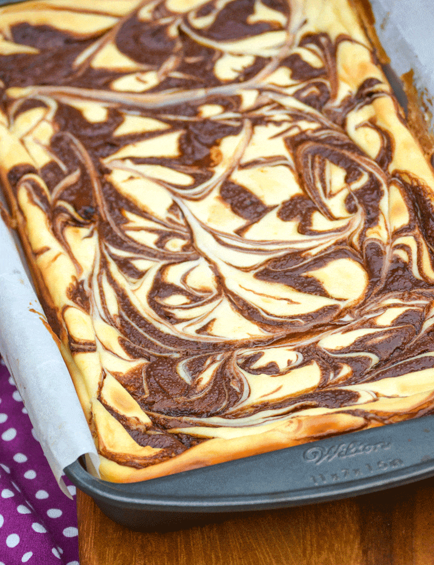 nutella cheesecake swirl brownies in a parchment paper lined baking pan