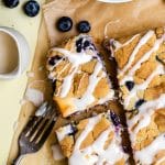 blueberry cheesecake sugar cookie bars on a wrinkled piece of brown parchment paper