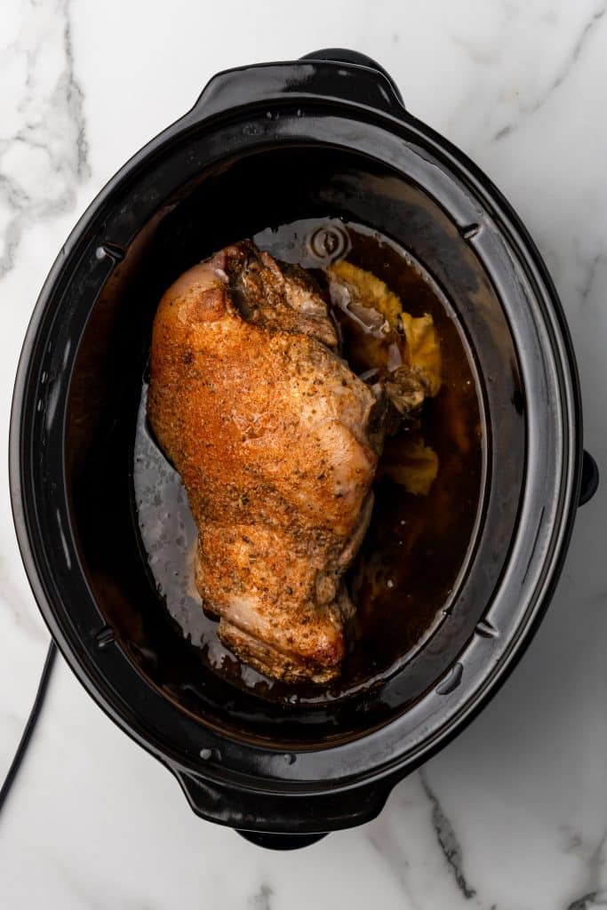 cooked pork shoulder in the bowl of a crockpot