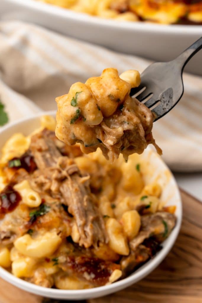 a fork holding up a scoop of pulled pork mac and cheese